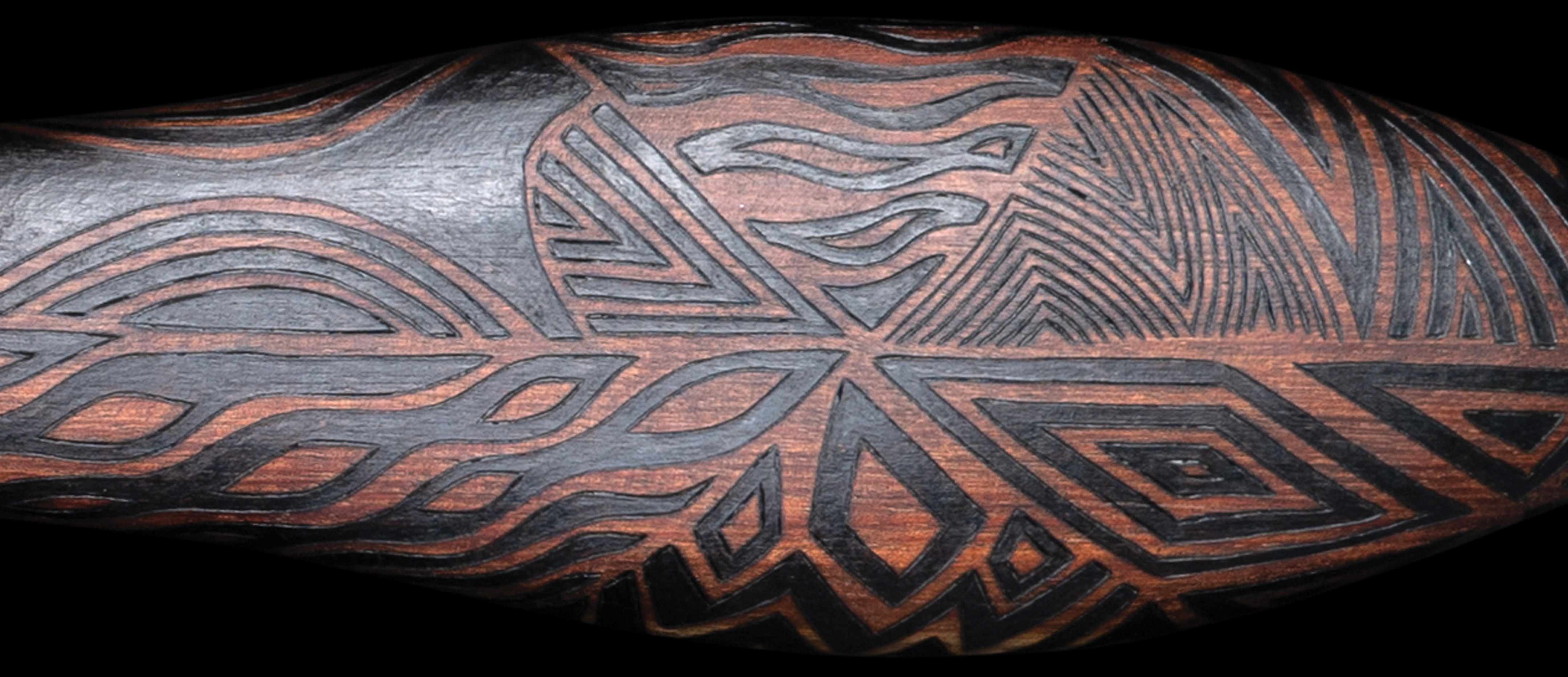 Indigenous club set on black background - wooden club with zig zag patterns